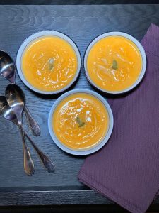 overhead shot of three bowls of squash soup