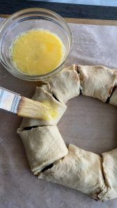 adding egg wash to top of wreath